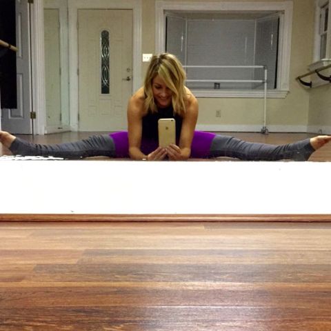 Clare Crawley in a purple top and a grey yoga pant working out in gym.